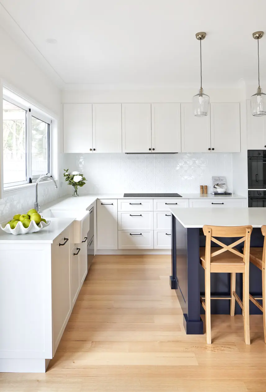 Spacious kitchen in Hobart featuring white cabinetry, modern fixtures, and elegant pendant lighting, designed by a skilled interior designer.